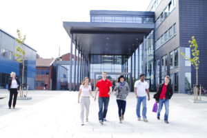 Photo of students in front of the main entrance of UiA's Campus Grimstad